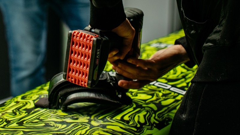 Components such as footstraps and fins are attached to the boards just before setting off.